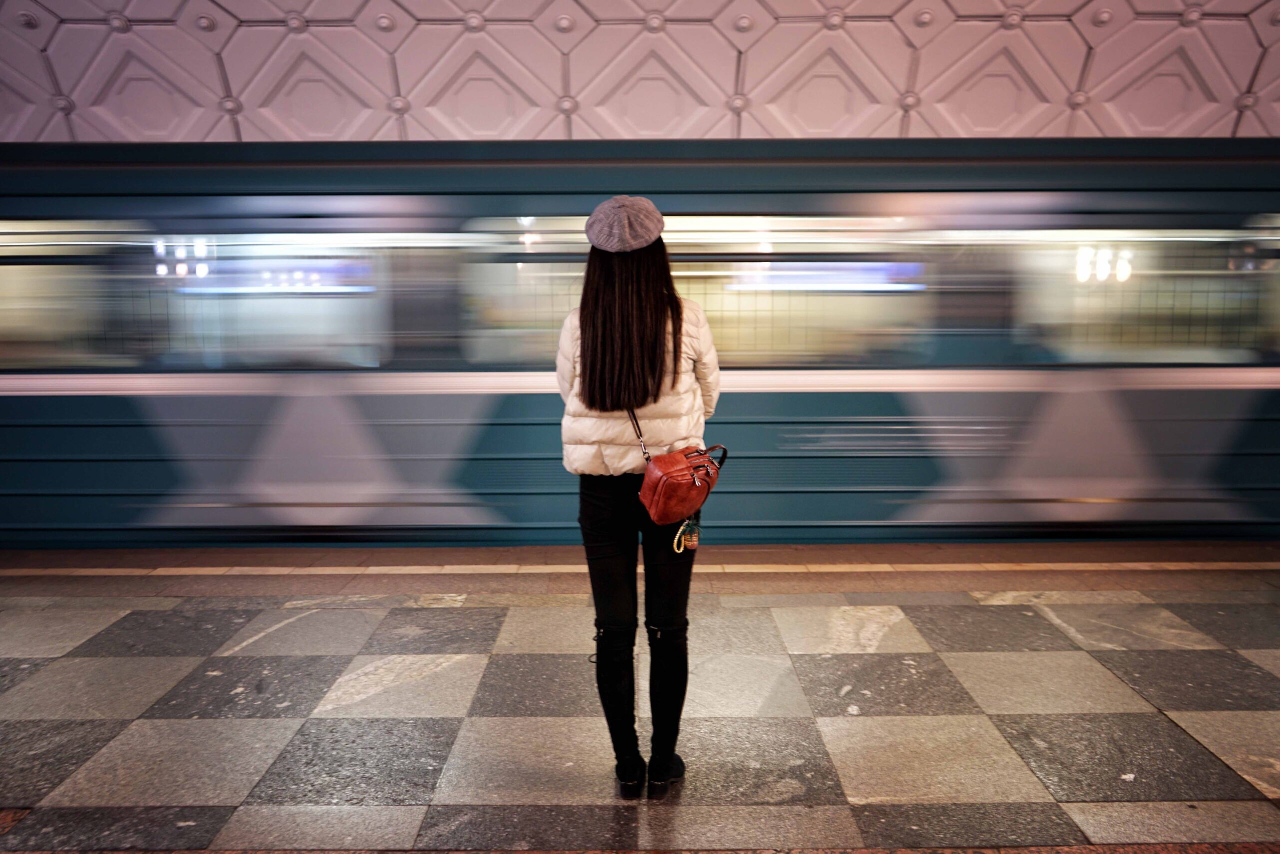 train whizzing by a woman at the station